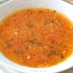 A white bowl filled with vegetable soup.
