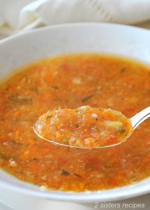 A spoonful of vegetable soup served in a white bowl.