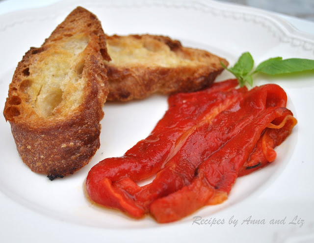 Roasted peppers on a white plate with two sliced of bread. by 2sistersrecipes.com