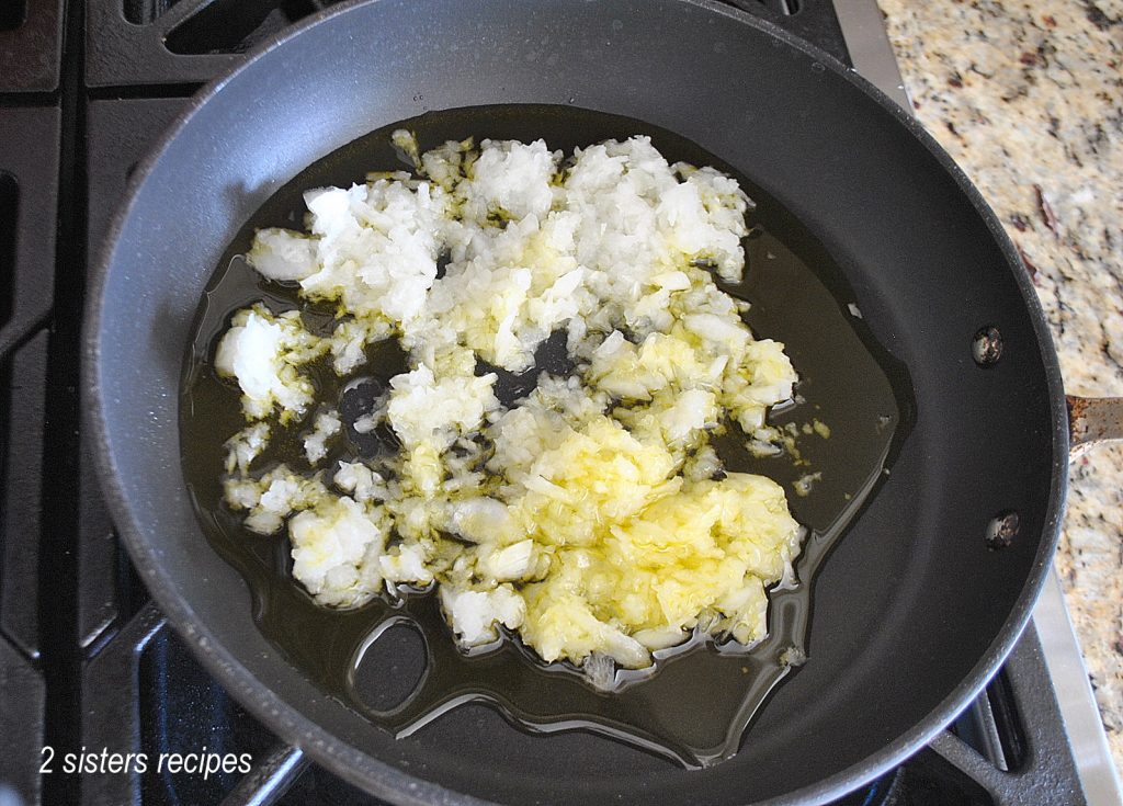 Minced onions are transferred to a skillet with olive oil. by 2sistersrecipes.com 