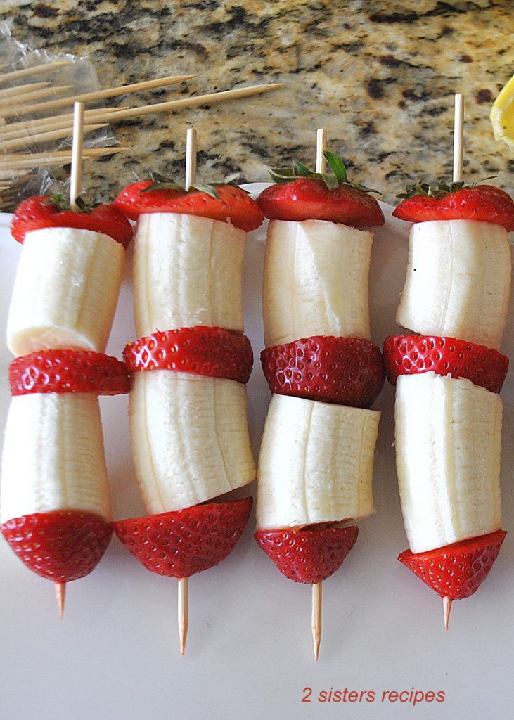 Threading the fruit pieces onto skewers. by 2sistersrecipes.com 