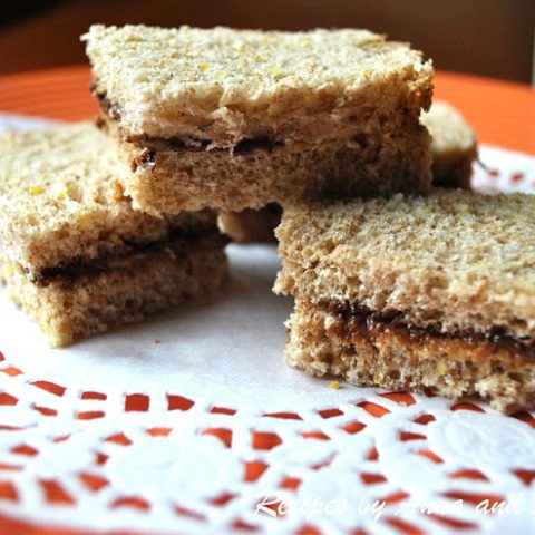 an Orange color plate with mini peanut butter and Nutella sandwiches. by 2sistersrecipes.com