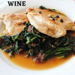 Chicken with Arugula and Wine served in a white dinner plate.