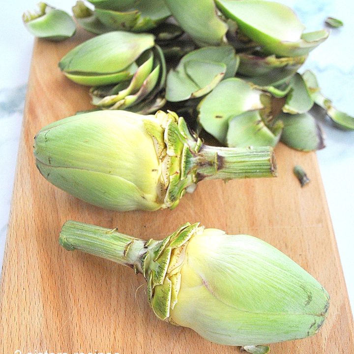 2 artichokes with its dark green leaves taken off.