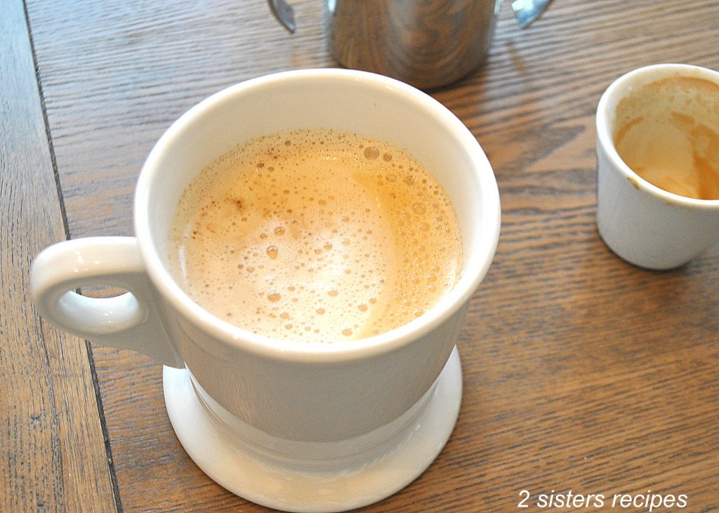 A white mug filled with caffe latte.