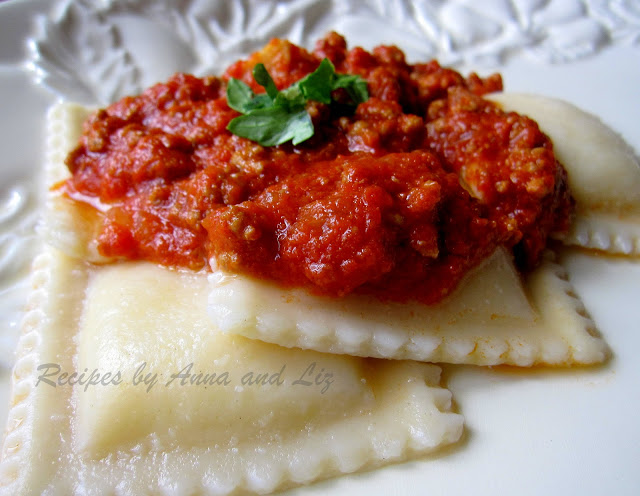 A closeup photo of ravioli with bolognese sauce on top.  by 2sistersrecipes.com