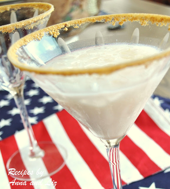 A cocktail glass with a white color liquid and crumbs on the rim of the glass.