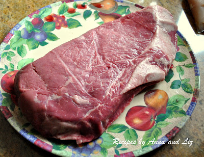Raw piece of London Broil steak on a plate. by 2sistersrecipes.com