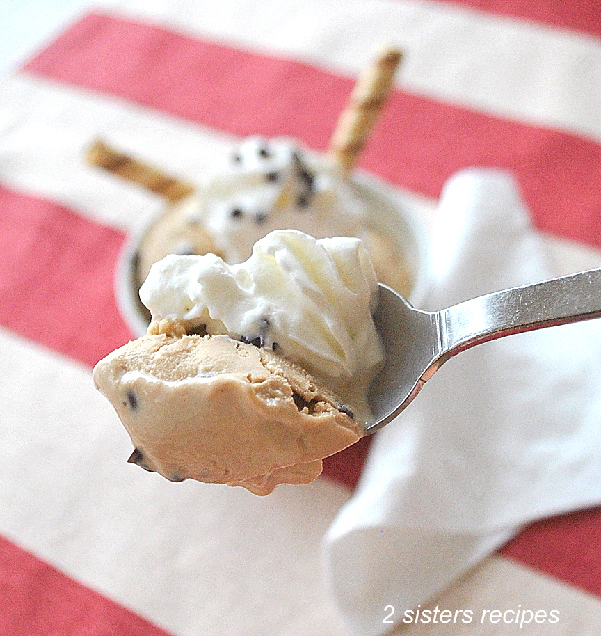 A spoonful of ice cream with whipped cream.  by 2sistersrecipes.com