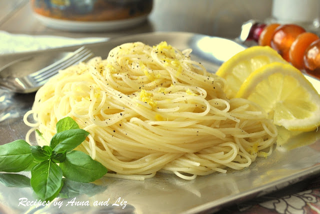 A silver platter with angel hair pasta and lemon slices. by 2sistersrecipes.com 