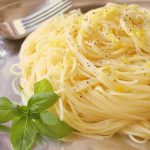 Angel Hair Pasta with Lemon Sauce on a silver platter with fresh basil on the side.