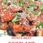 Eggplant parmesan topped with tomato sauce and fresh basil.