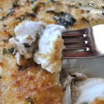 A forkful of cooked white fish.