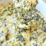 A tortilla chip filled with a spinach and artichoke dip.