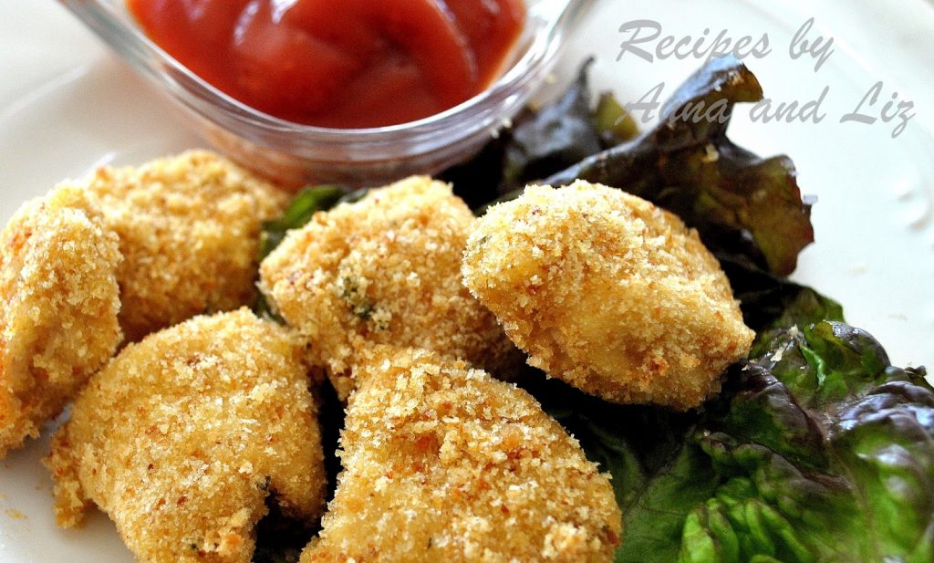 A plate filled with baked chicken nuggets.
