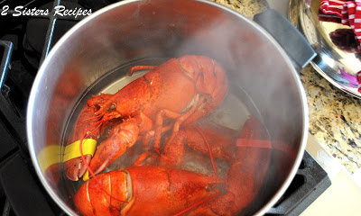 a photo of a live lobsters in a large pot of water. by 2sistersrecipes.com 
