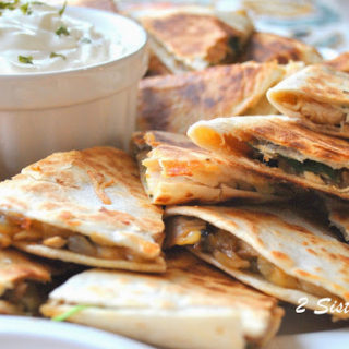 A large white platter filled with small quesadillas. by 2sistersrecipes.com