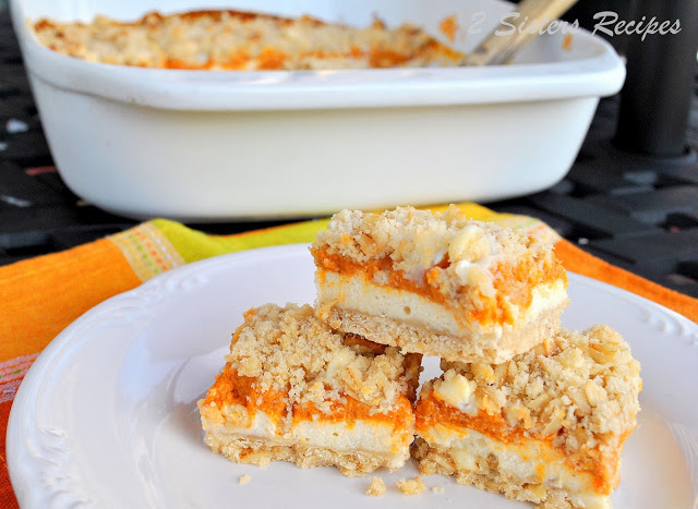 photo of cheesecake pumpkin bars on a plate for serving. by 2sistersrecipes.com 