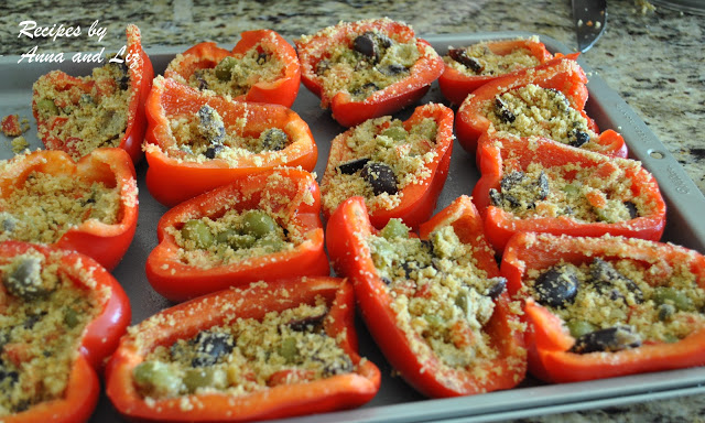 Red bell peppers sliced in halves and stuffed on a baking sheet. by 2sistersrecipes.com