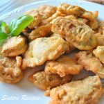 A white plate filled with Artichoke heart fritters.