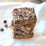 A pile of chocolate bars topped with crushed nuts.