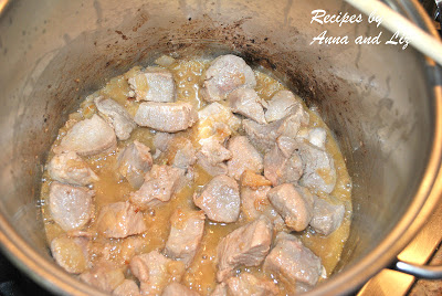 A large pot with chunks of veal cooking inside.