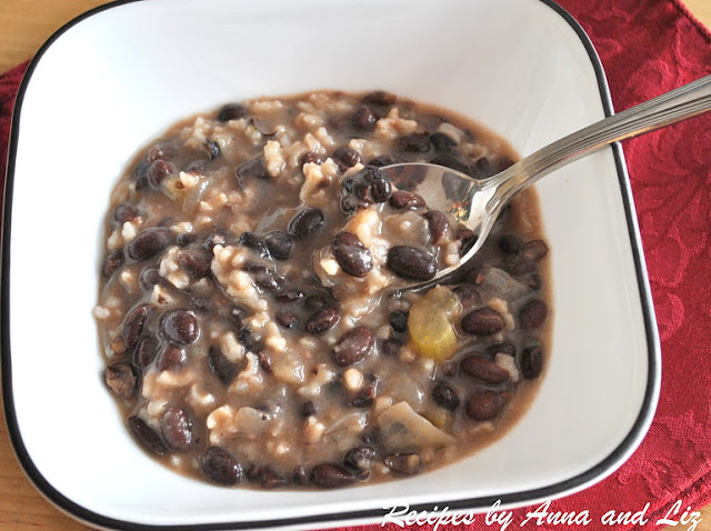 A bowl of a beans and rice soup with a spoon.