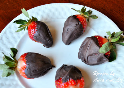 A white plate with 5 strawberries covered in chocolate.