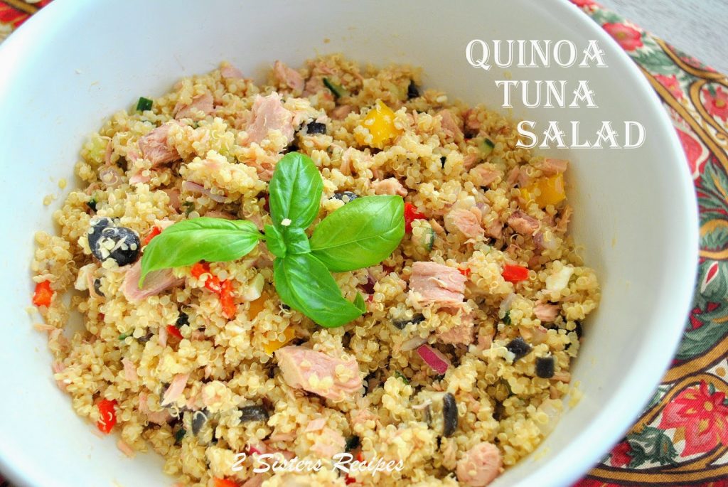 Quinoa salad mixed with tuna and veggies served in a white bowl. 