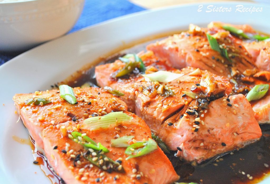 Filets of Salmon cooked and served on white platter with sauce.
