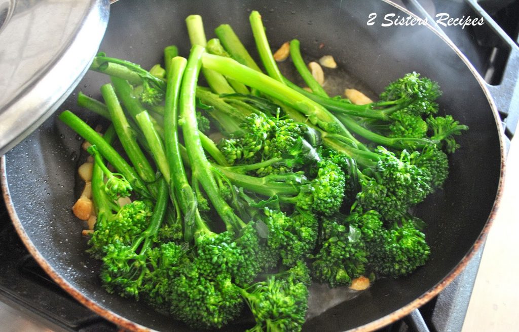 A black skillet filled with fresh broccolini.