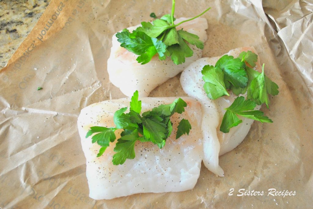 3 raw cod fillets with fresh parsley sitting on top. by 2sistersrecipes.com 