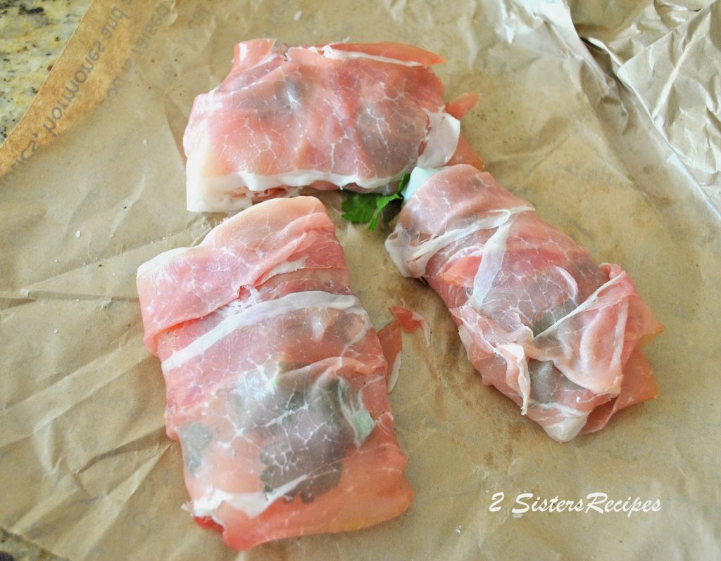 3 Fillets of cod are wrapped with prosciutto. by 2sistersrecipes.com  