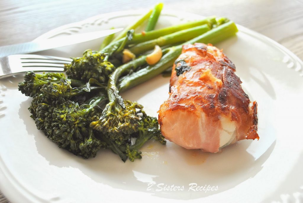 Easy Cod Saltimbocca is on a white plate with broccolini on the side. by 2sistersrecipes.com