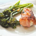 Easy Cod Saltimbocca is on a white plate with broccolini on the side.