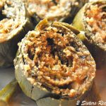 A plate with four stuffed artichokes.