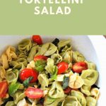 A tortellini pasta salad with cherry tomatoes, served in a white salad bowl