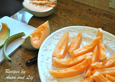 A white platter filled with sliced of cantaloupe melon. 