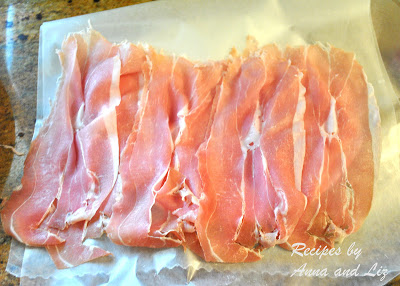 A sheet of wax paper with a single layer of thinly sliced prosciutto.