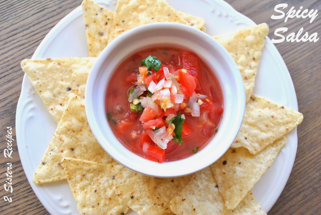 A white bowl filled with salsa, and tortilla chips served around it.