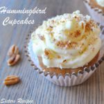 One cupcake topped with cream cheese frosting and chopped pecans.