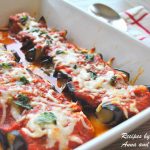 A casserole dish filled with Eggplant Rollatini topped with tomato sauce and melted cheese.