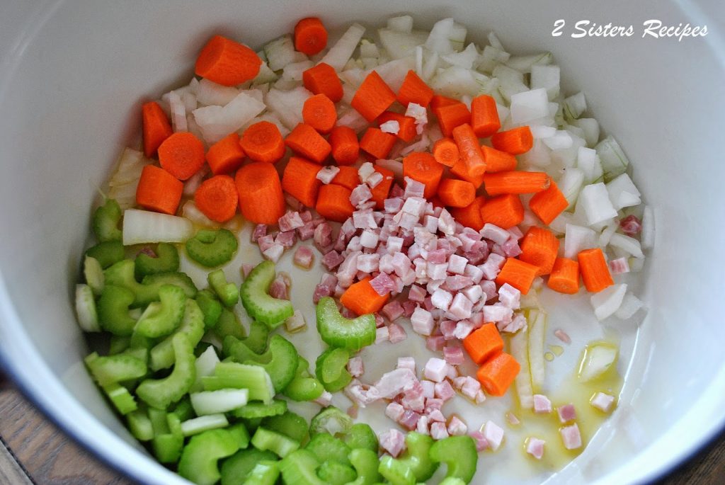 A large soup pot filled with raw chopped vegetables to sauté as the first step. by 2sistersrecipes.com