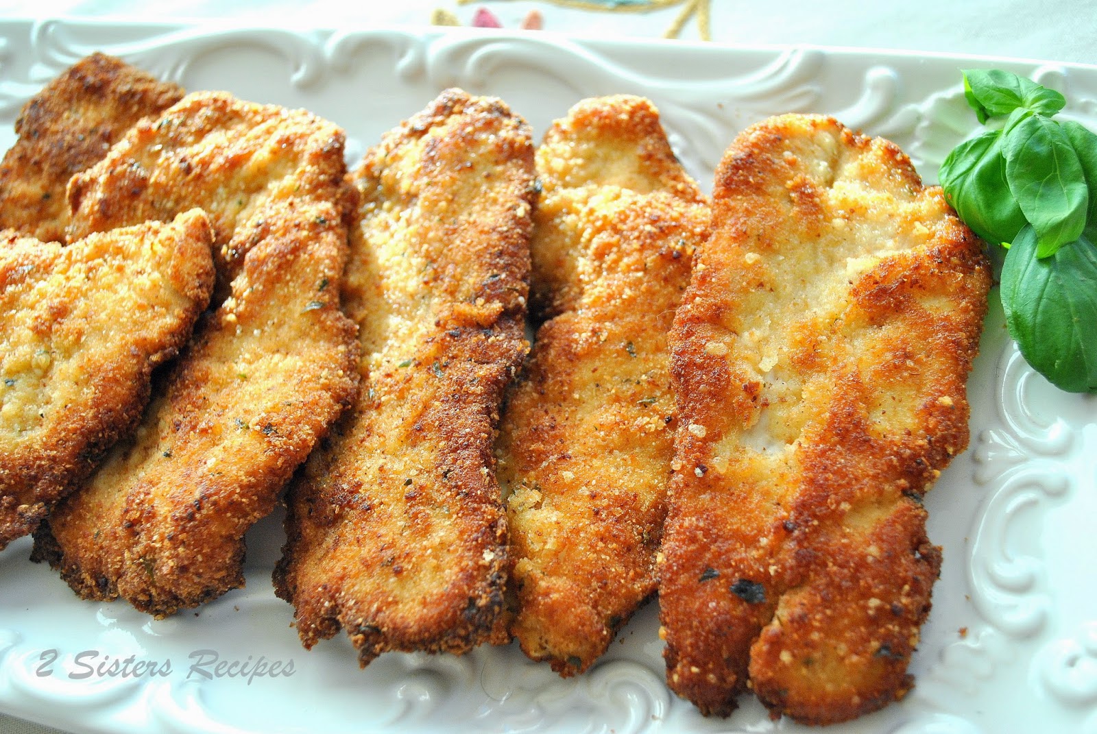 5 golden brown cooked cutlets on a white platter.