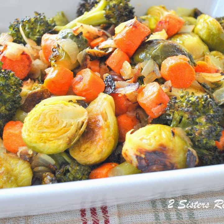 A white casserole dish filled with roasted mixture of vegetables.