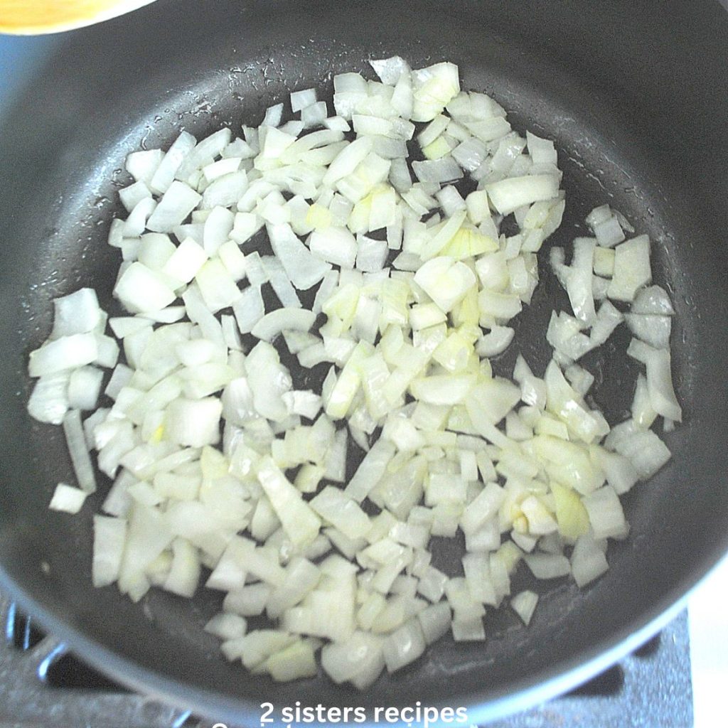 Chopped onions sauteing in a soup pot. by 2sistersrecipes.com