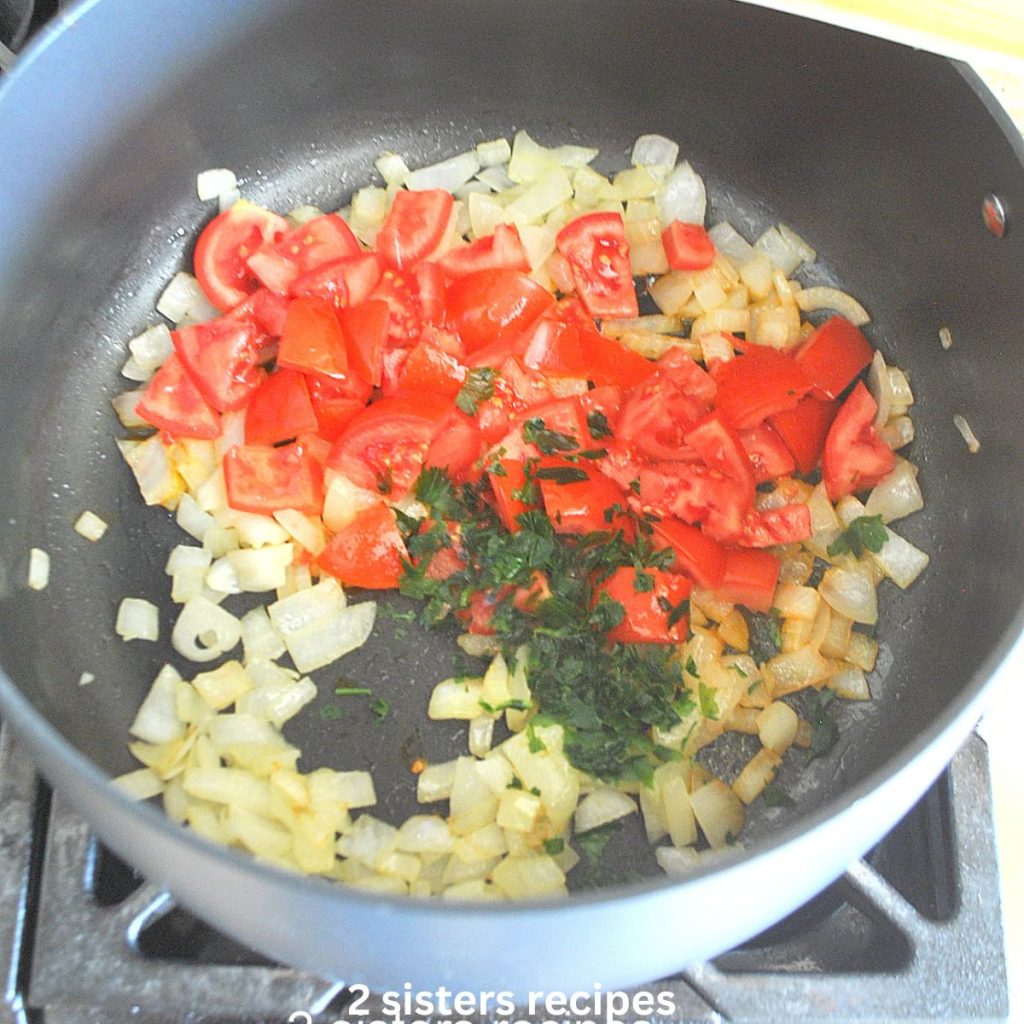 A soup pot with chopped onions and tomatoes. by 2sistersrecipes.com