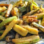 A platter filled with sautéed zucchini sticks.