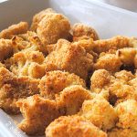 A white baking dish filled with roasted cauliflower au gratin.