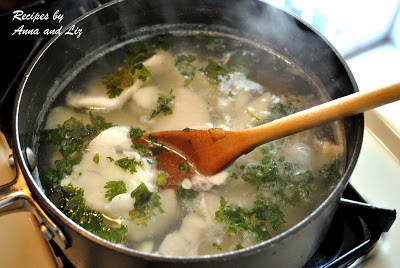 A pot on stove top boiling the fish in wate with parsley. by 2sistersrecipes.com